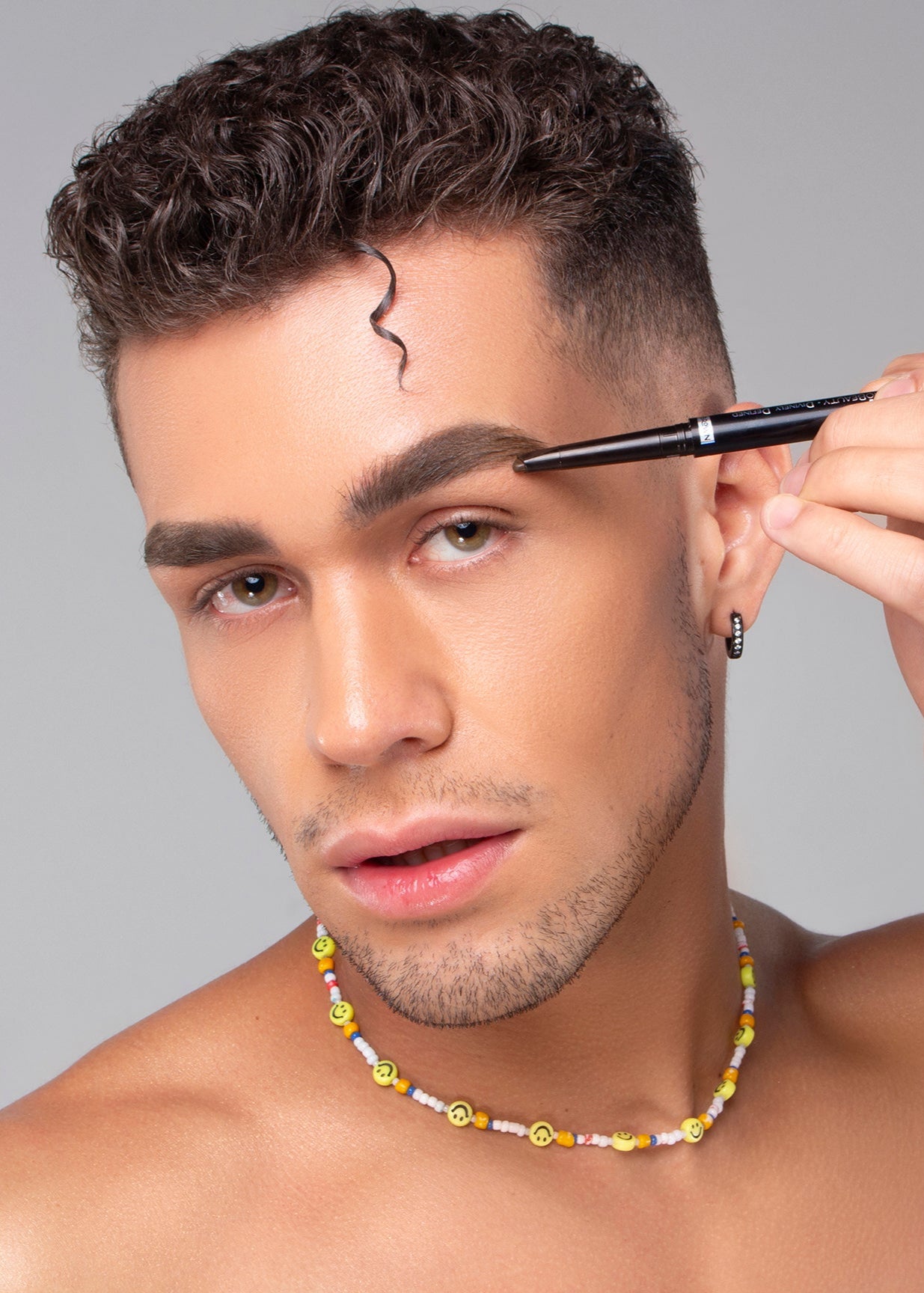 Model applying Mo-Beauty Shop's Divinely Defined Thick, Angled Tip Brow Pencil + Brush in the Dark Brown shade.