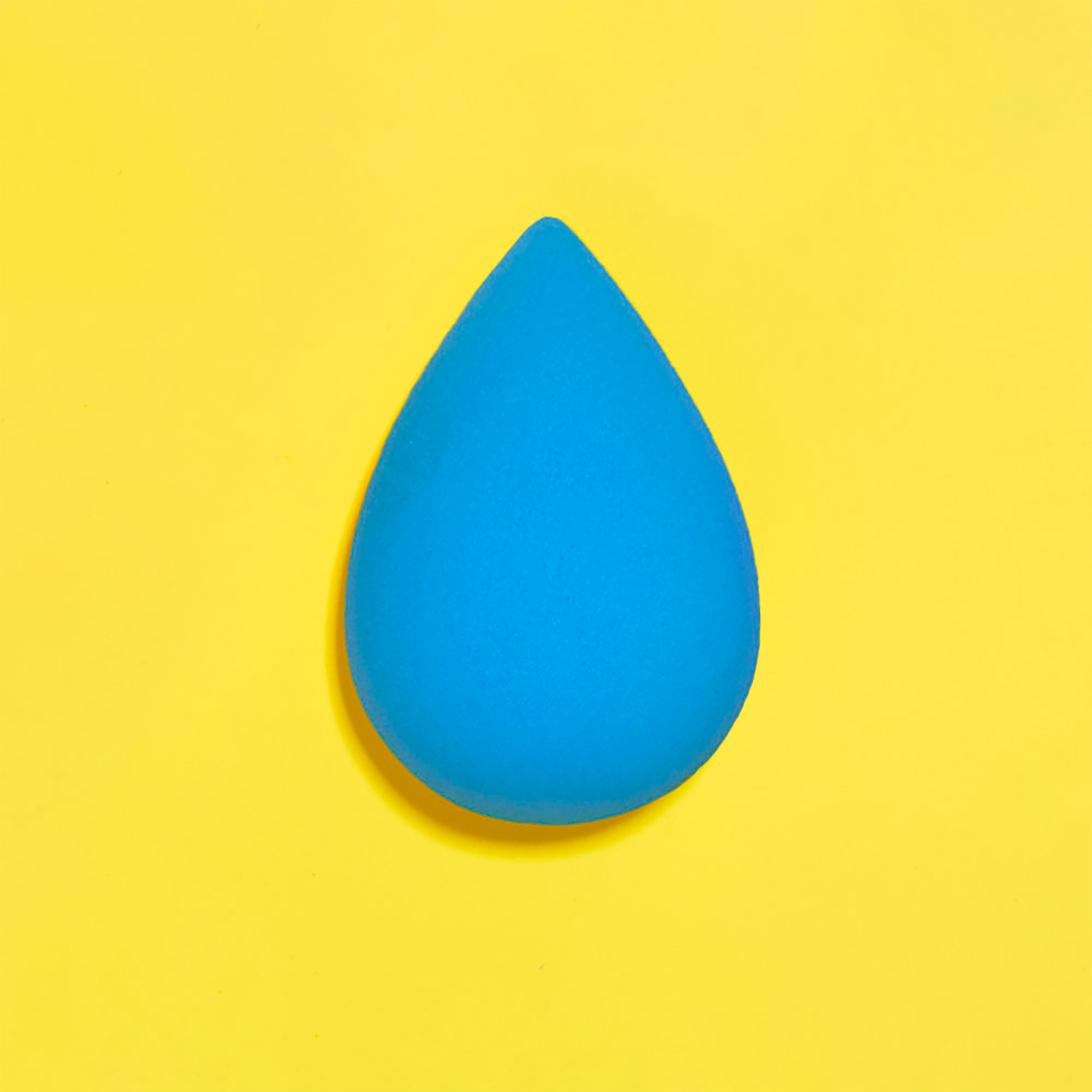 Blue makeup sponge on a yellow background