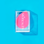 Mo-Beauty Shop's teardrop-shaped, latex-free Cosmetic Blender in the color Pink, sitting inside its clear packaging.