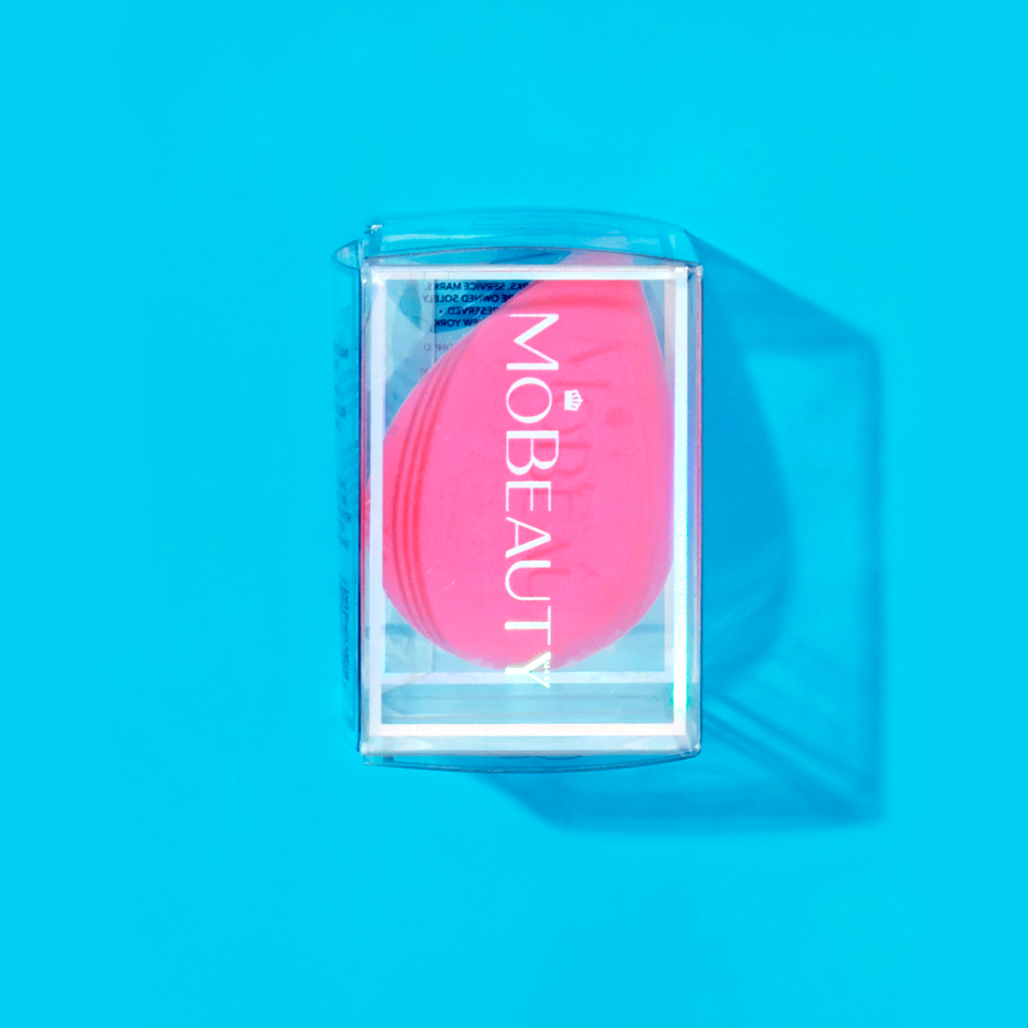 Mo-Beauty Shop's teardrop-shaped, latex-free Cosmetic Blender in the color Pink, sitting inside its clear packaging.