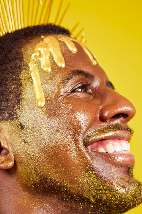 Model dripping in Mo-Beauty Shop's Gimme Mo-Glow All-Over Highlighter in the Gold shade.